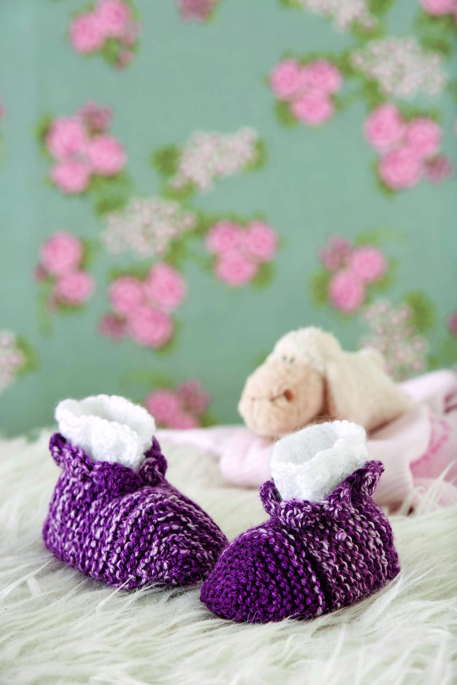 Lila gestrickte Babyschuhe, kuscheliger Futterrand, handgemacht, DIY, klassische Nähkunst.