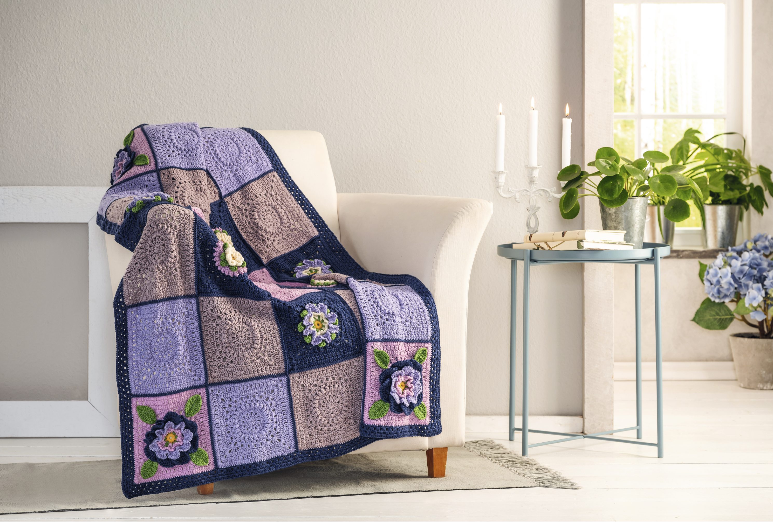 XXL-Granny-Square-Decke mit Blüten-Grannys (mit Lehrgang) Bunte, gehäkelte Decke mit Blumenmuster, in Violett- und Blautönen. Modisch handgemacht, ideal für gemütliches Ambiente.