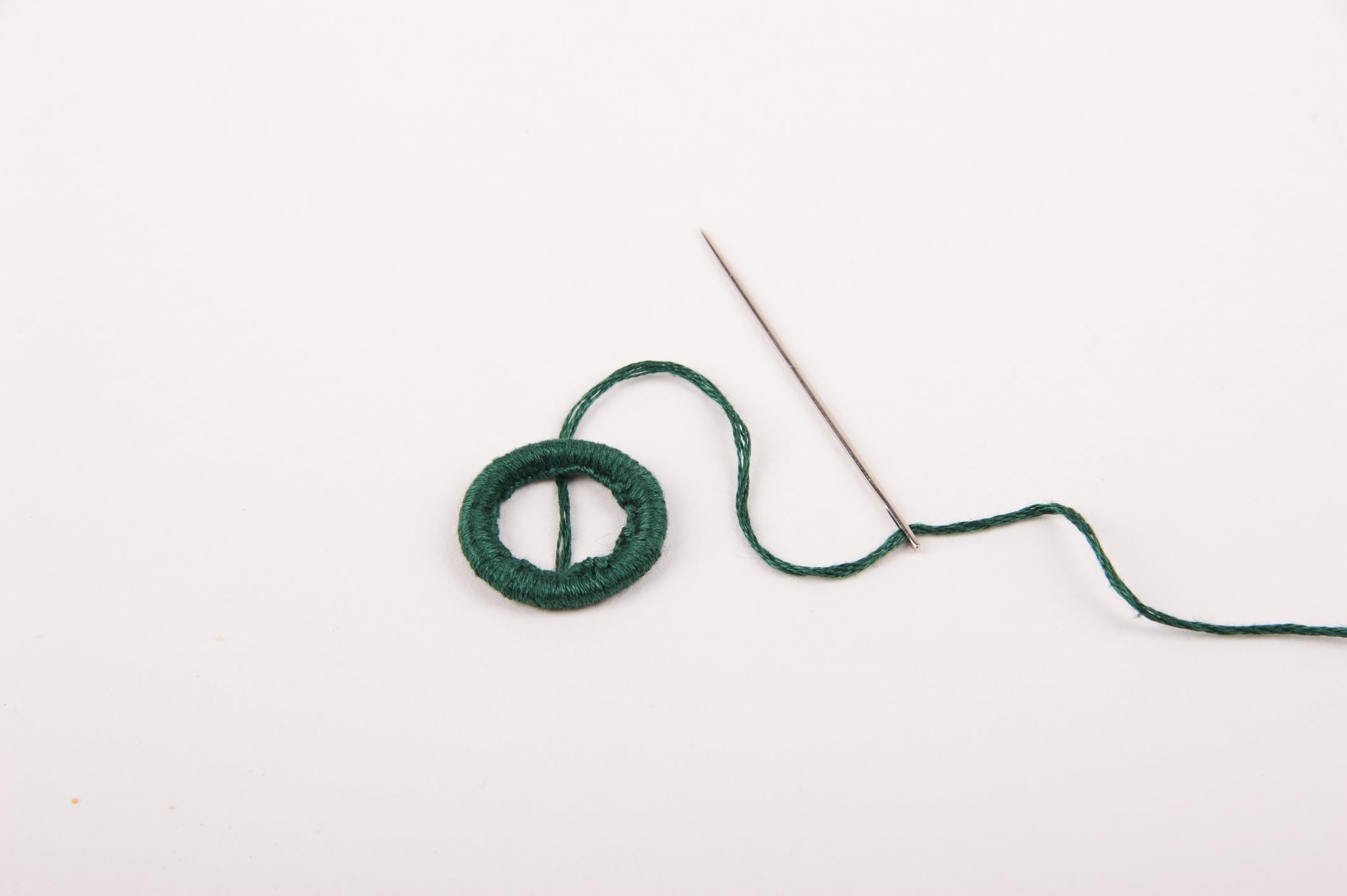 Grüner Faden mit Sticknadel. Handarbeit, einfach, kreativ, modisch.