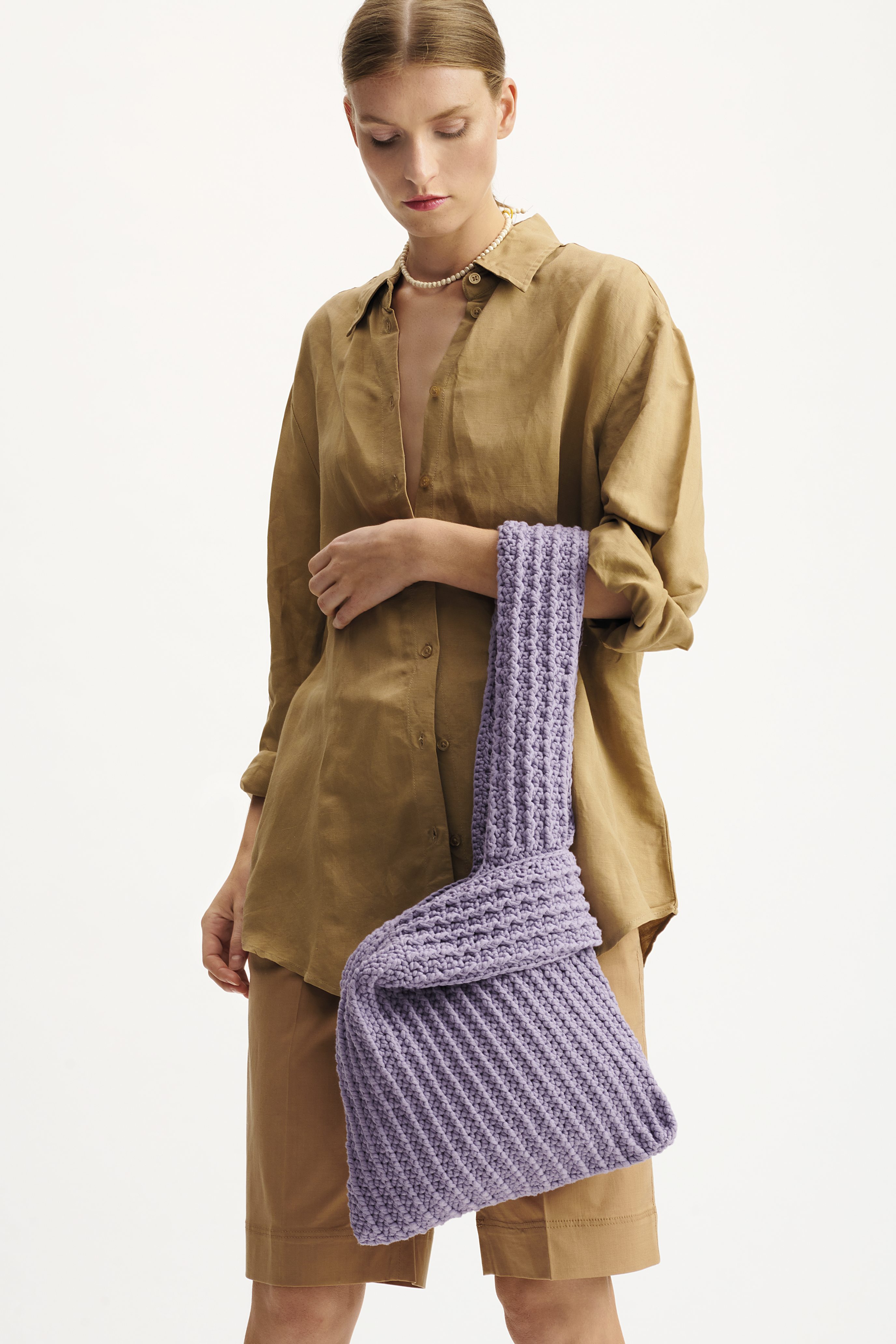 Beigefarbenes Hemd, Bermuda-Shorts, handgemachte lilafarbene Häkel-Tasche, modisch und trendig.