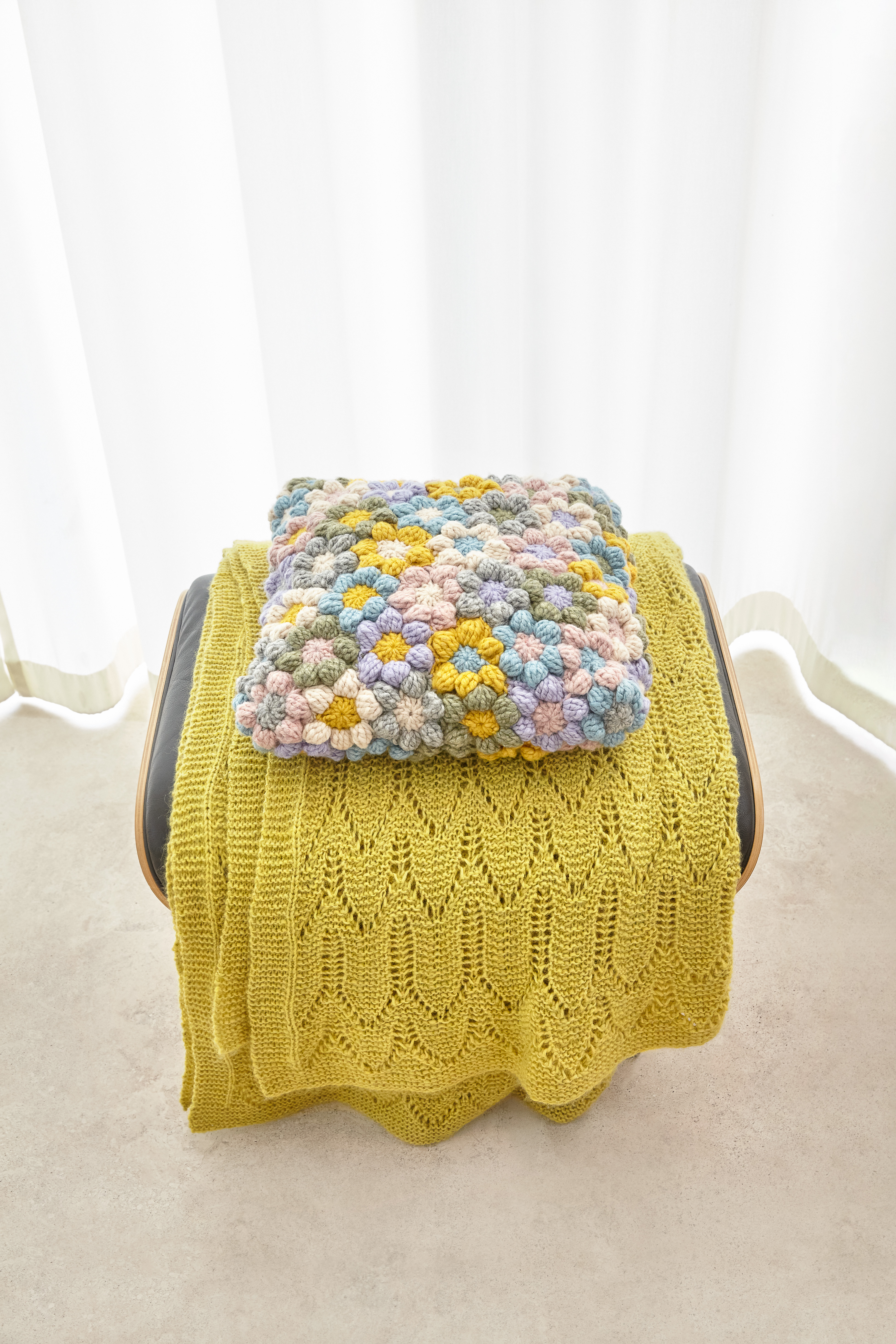 Gestrickte gelbe Decke mit Zopfmuster, bunte, handgemachte Häkeldecke. DIY, kunstvoll, kreativ.