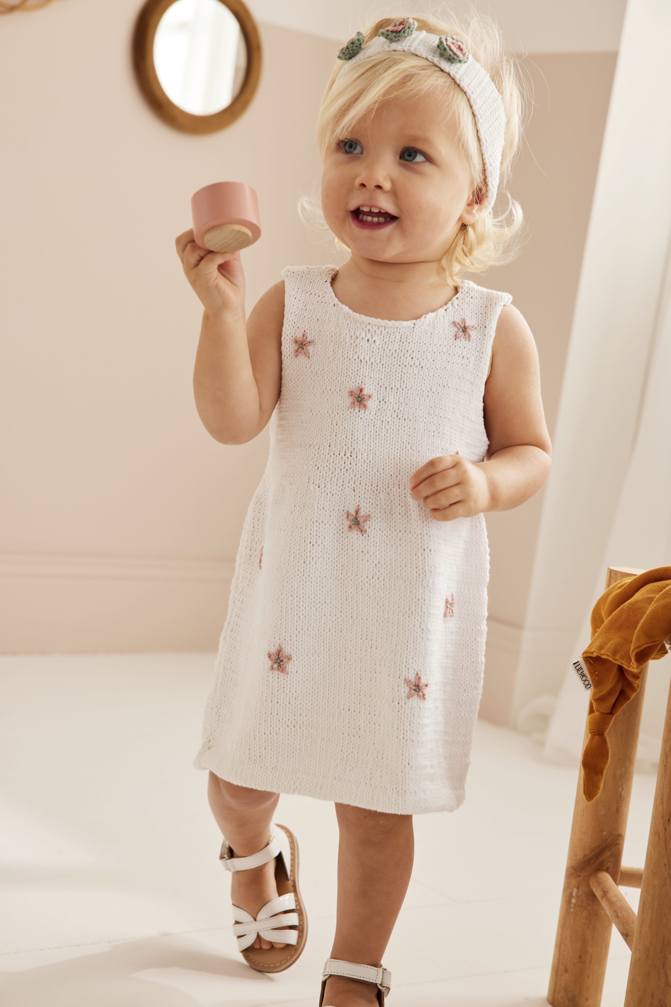 Weißes Strickkleid mit rosa Blumenmuster, ärmelloser Schnitt, modisch, handarbeit, DIY-Look.