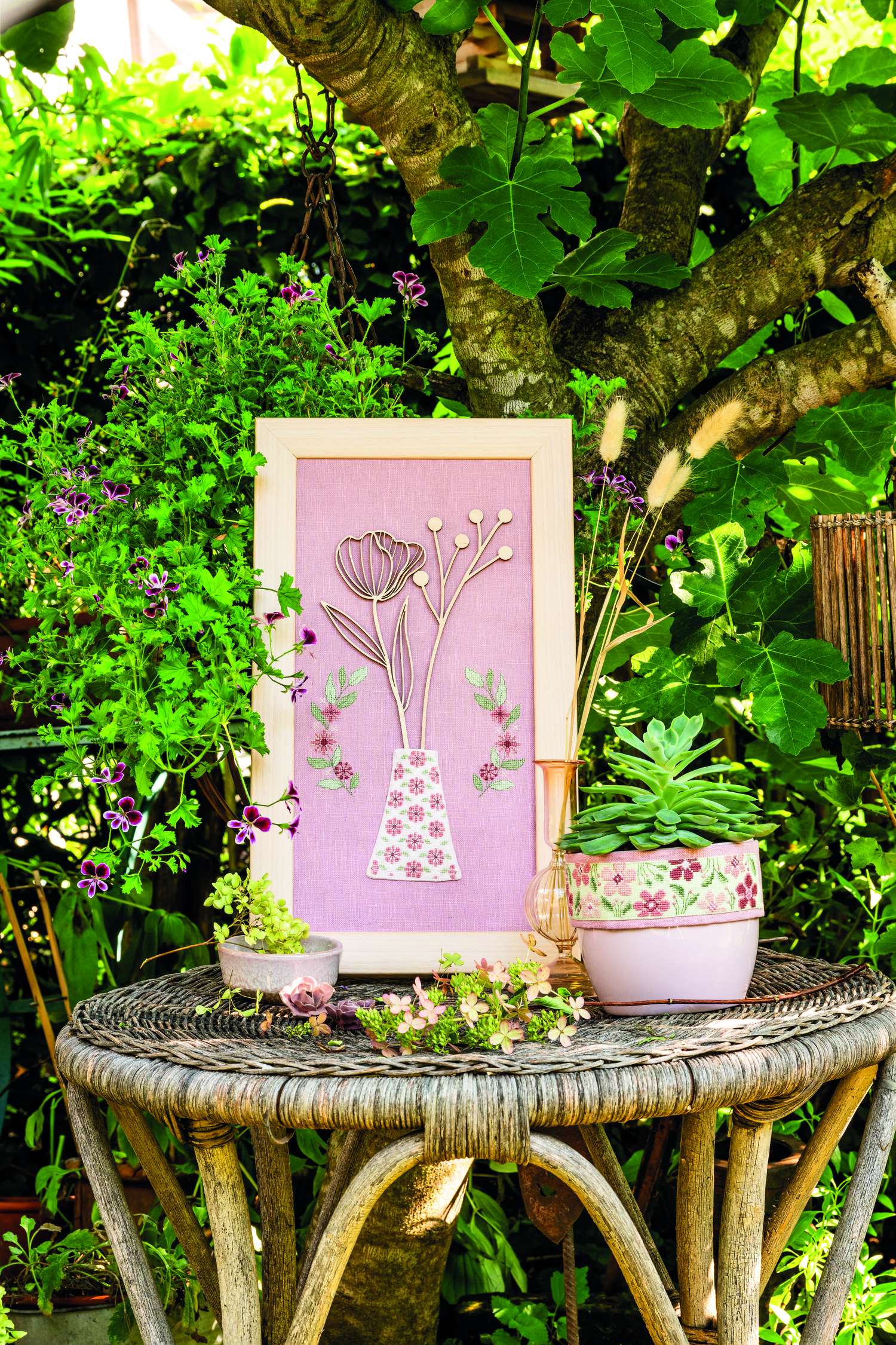 Selbstgemachte Wanddeko mit floralem Muster auf rosa Stoff. Handarbeit mit Holzrahmen. Stil: DIY, modisch.