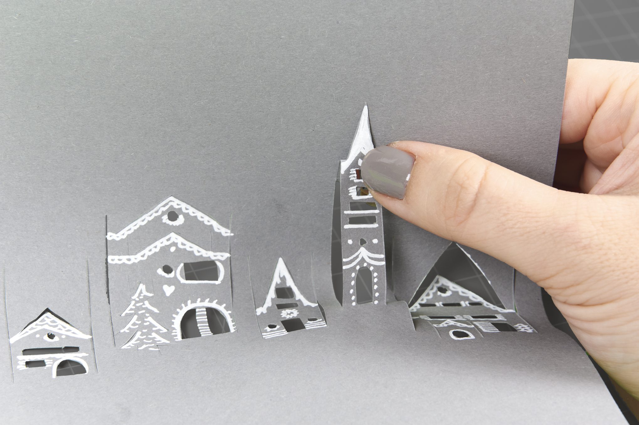 Selbstgemachte graue Papierstadt mit filigranen weißen Details. DIY, handgemacht, kunstvoll.