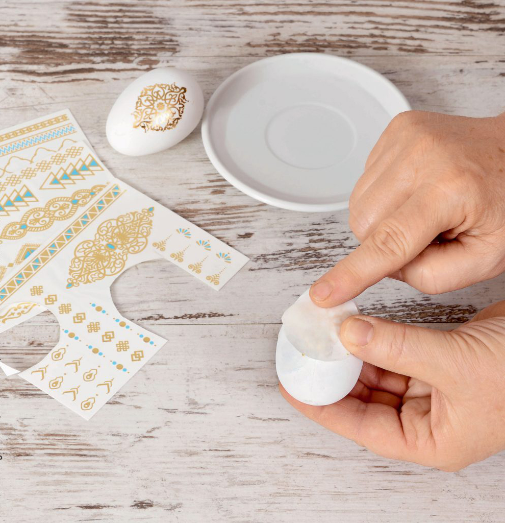Handgemacht: Ei mit goldenen, floralen Mustern verziert. DIY-Set, elegant und detailreich.