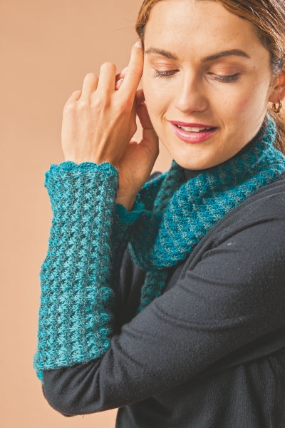 Modisches Ensemble aus blauem, gehäkeltem Schal und Armstulpen. Handgemacht, strukturierter Look.