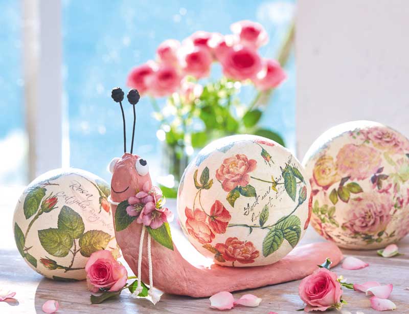 Pinke Schnecke und Kugeln mit Rosenmuster, DIY-Handarbeit, farbenfroh und kreativ gestaltet.