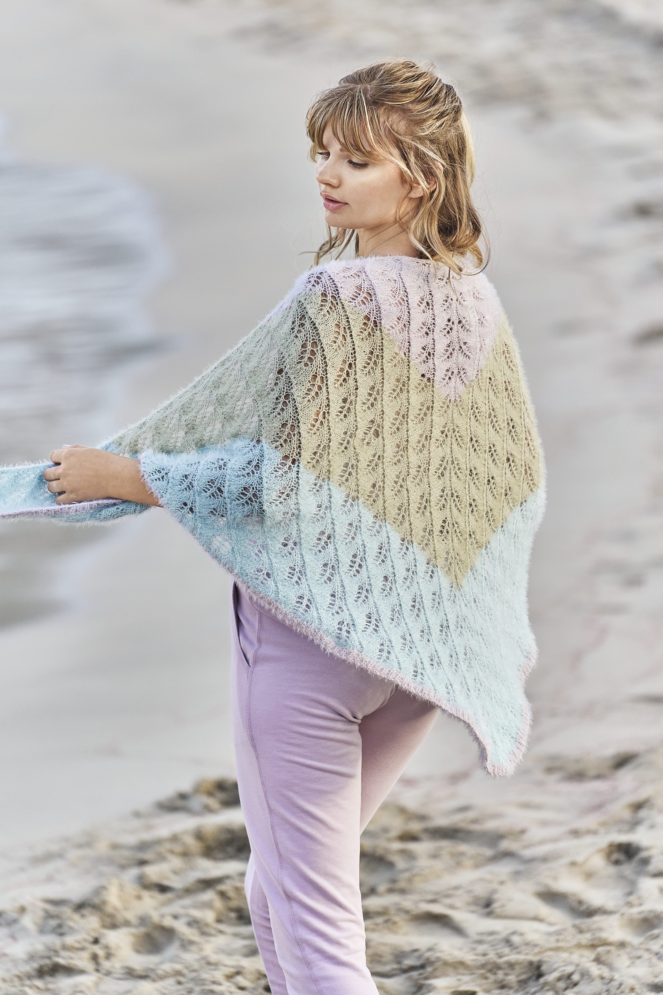 Handgestrickter Poncho in zarten Pastellfarben, florales Muster, modisch und selbstgemacht. Perfekt für den Strand.