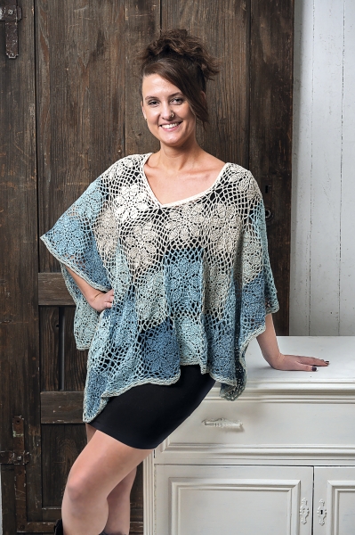 Handgemachtes Poncho in Blau- und Beigetönen. Luftige Maschen, lockerer Schnitt, DIY-Look, ideal für stilvolles Layering.