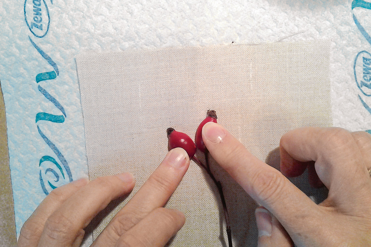 Handarbeit: Stoff in Naturtönen mit handgemachten roten Akzenten, präzise Muster, modisch und kreativ.