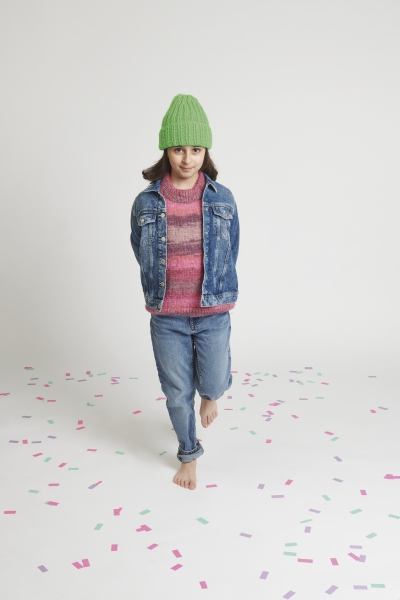 Grüne Mütze, rosa Pullover, Jeansjacke, blaue Jeans. Farbe und Muster kreativ gemischt, modisch und vielseitig.