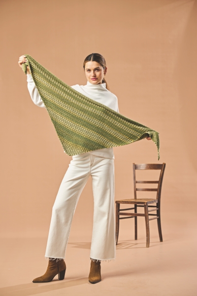 Modischer, handgemachter grüner Schal mit weißem Outfit, weite Hosen, schlichtes Design, elegant, stilvoll.