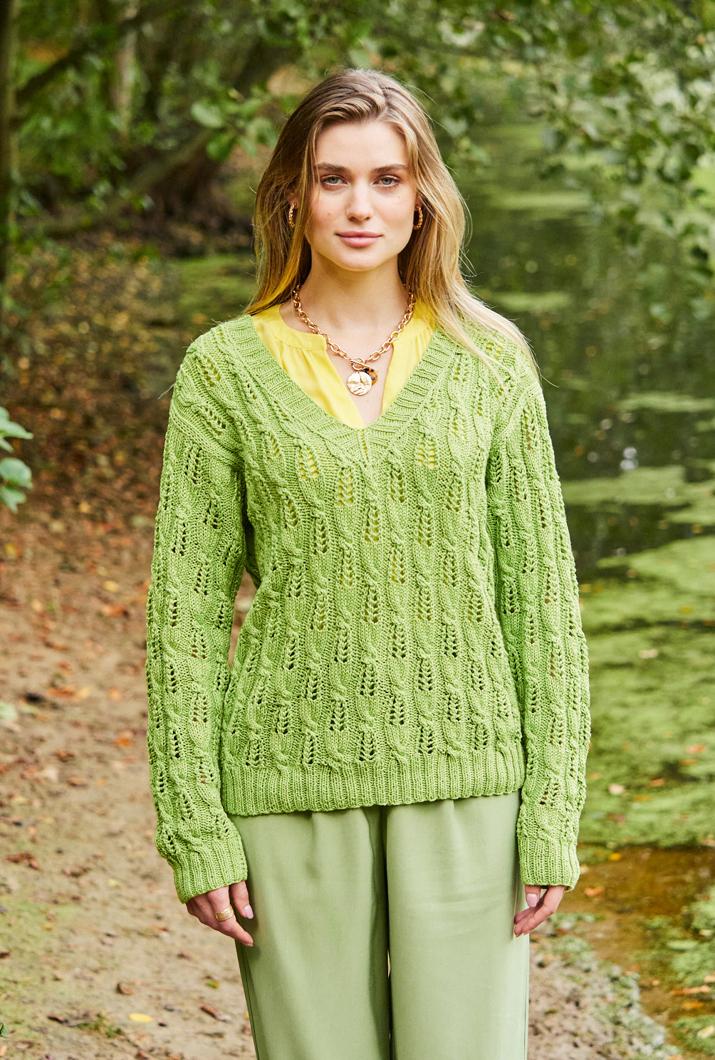 Modellansicht Bild 2: Pullover mit V-Ausschnitt und Zopf-Lochmuster in Grün