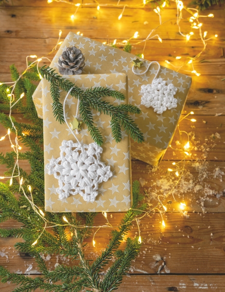 Geschenke in goldener Sternoptik mit handgemachten, gehäkelten Schneeflocken. Modisch und kreativ.
