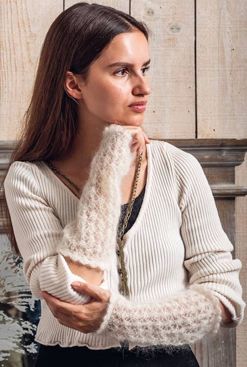 Weiße, gerippte Jacke kombiniert mit handgestrickten, flauschigen Armstulpen. Modisch und einzigartig.