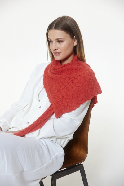 Roter Schal mit Zopfmuster über weißem Outfit; handgearbeitet, modisch und elegant.