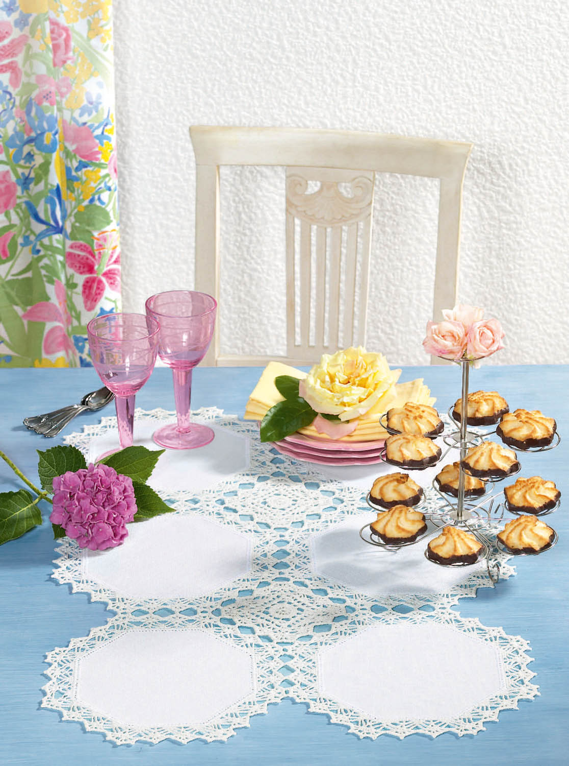 Selbstgemachte weiße Spitzendecke, rosa Gläser, florale Akzente, feine Pastellfarben. Modisch, handgefertigt, elegant.