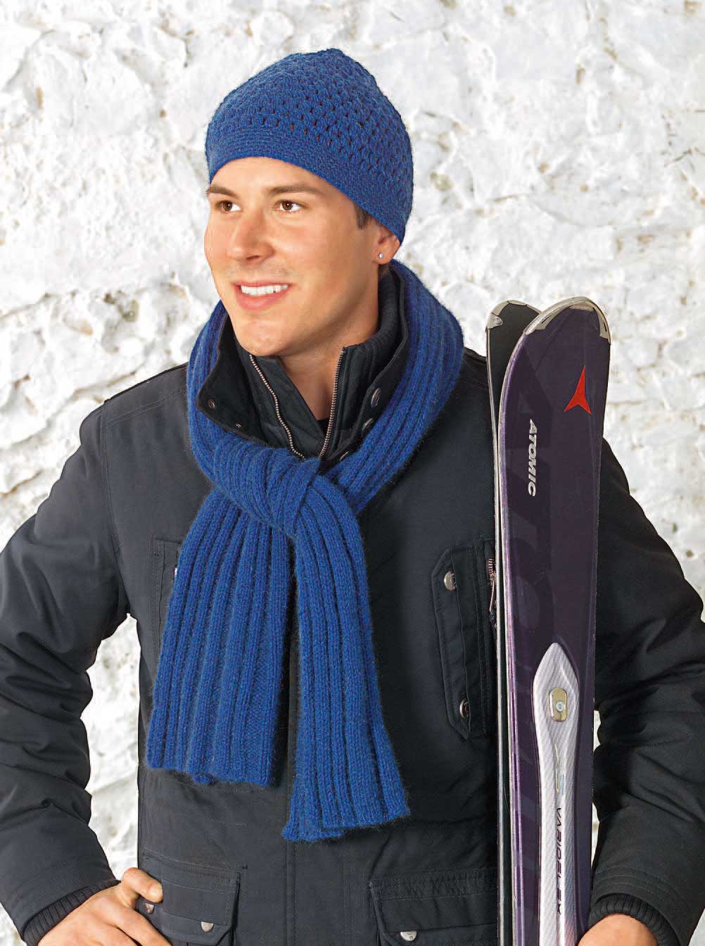 Modische blaue Mütze und Schal, handgestrickt. Jacke in dunklem Farbton, ideal für kalte Tage.