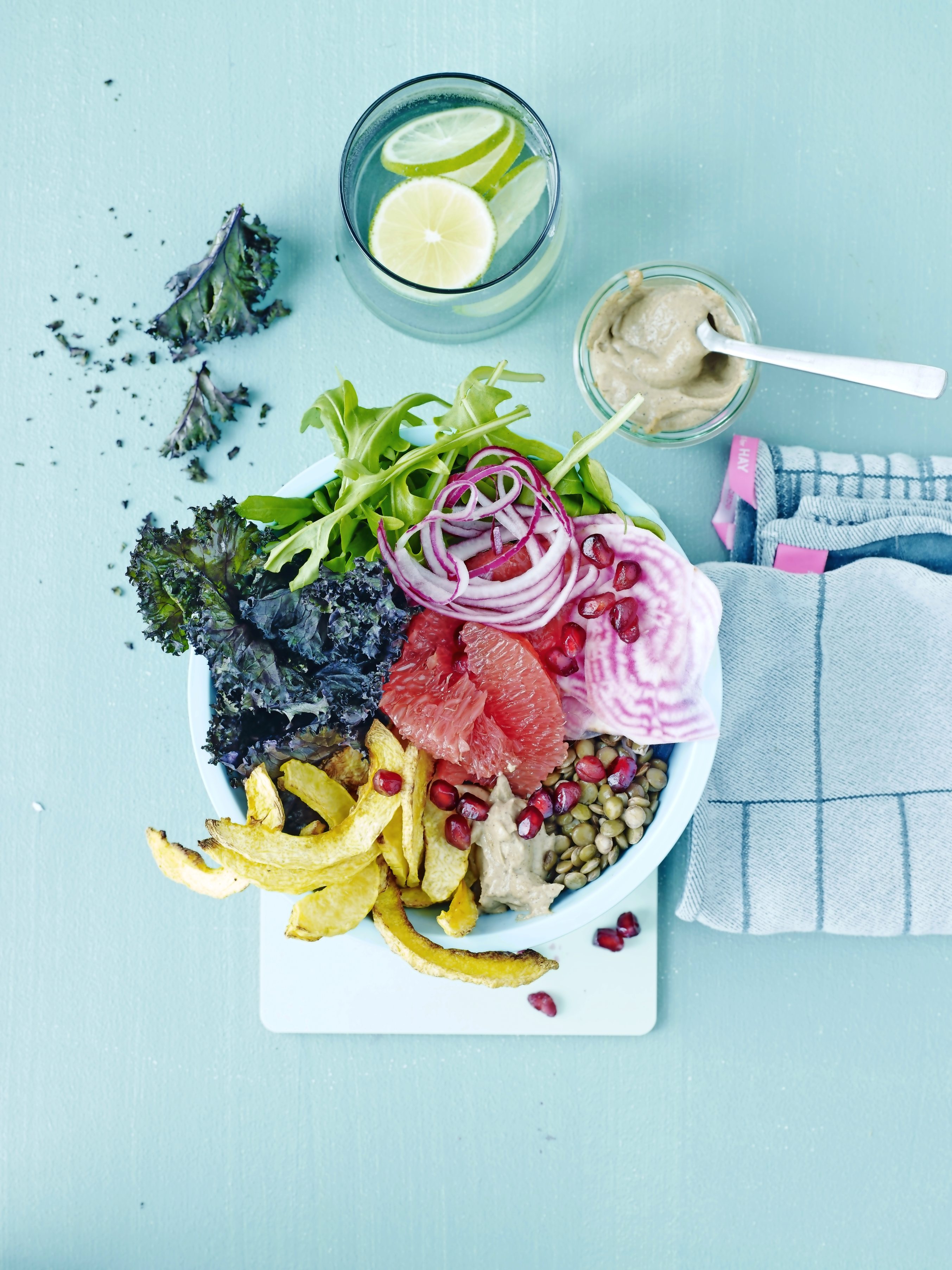 Bunte Schüssel: Grünkohl, Rucola, Grapefruit, rote Zwiebelringe, Linsen, Pommes. Farbenfroh und gesund.