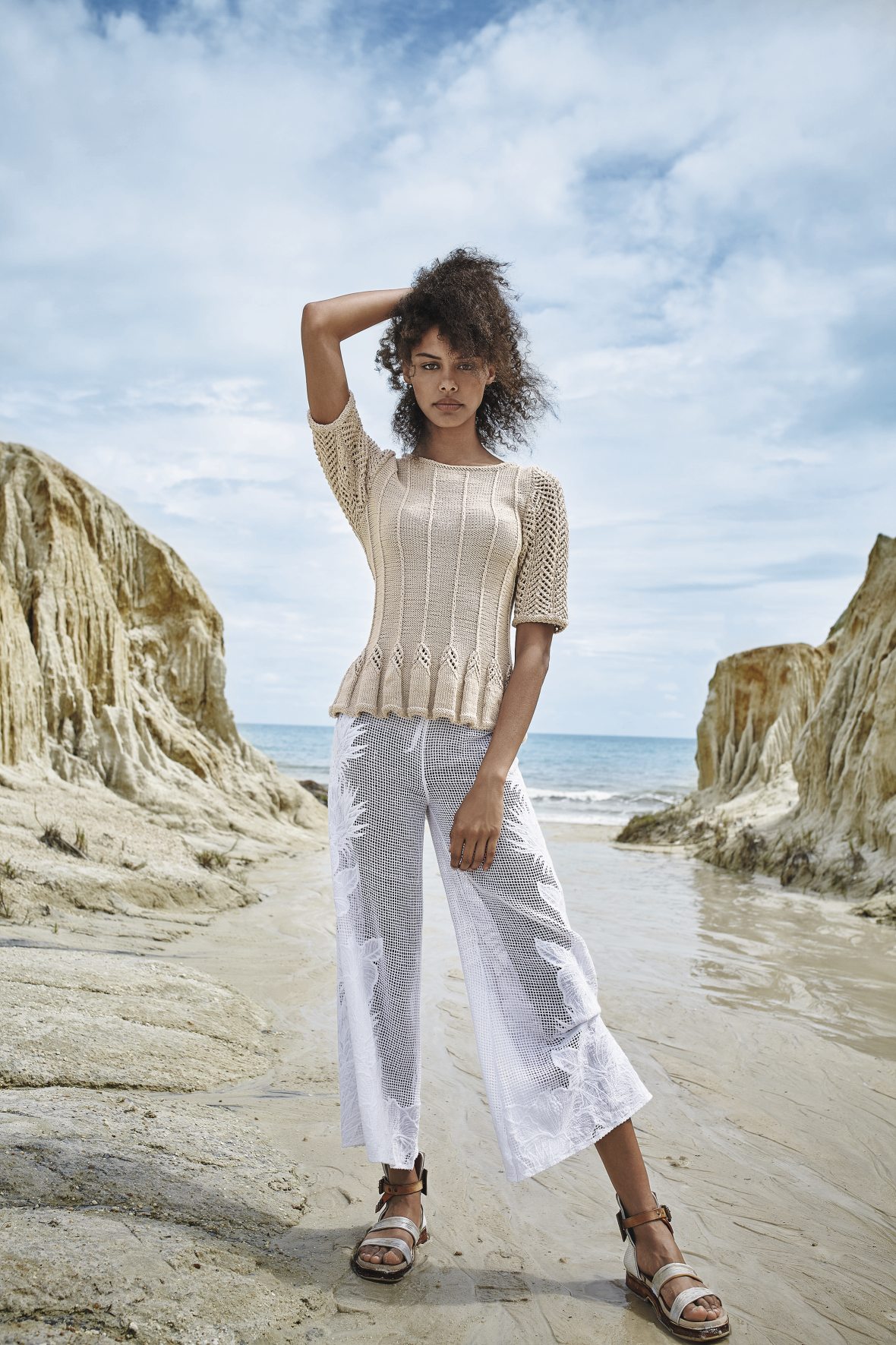 Beiges Stricktop, kunstvoll gemustert. Weiße, weit geschnittene Spitzenculottes. Modischer DIY-Look.