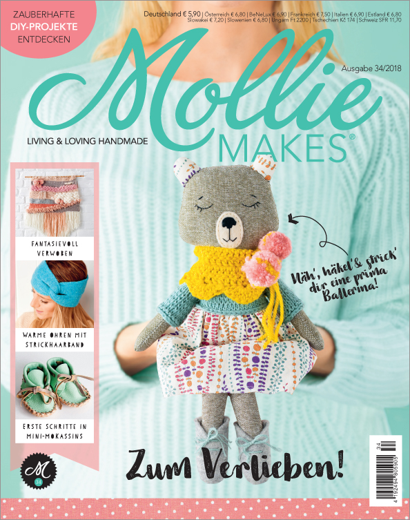 Bunter, gestrickter Bär in DIY-Stil; gelber Schal, pastellfarbiges Kleid; modisch, kreativ, individuell.