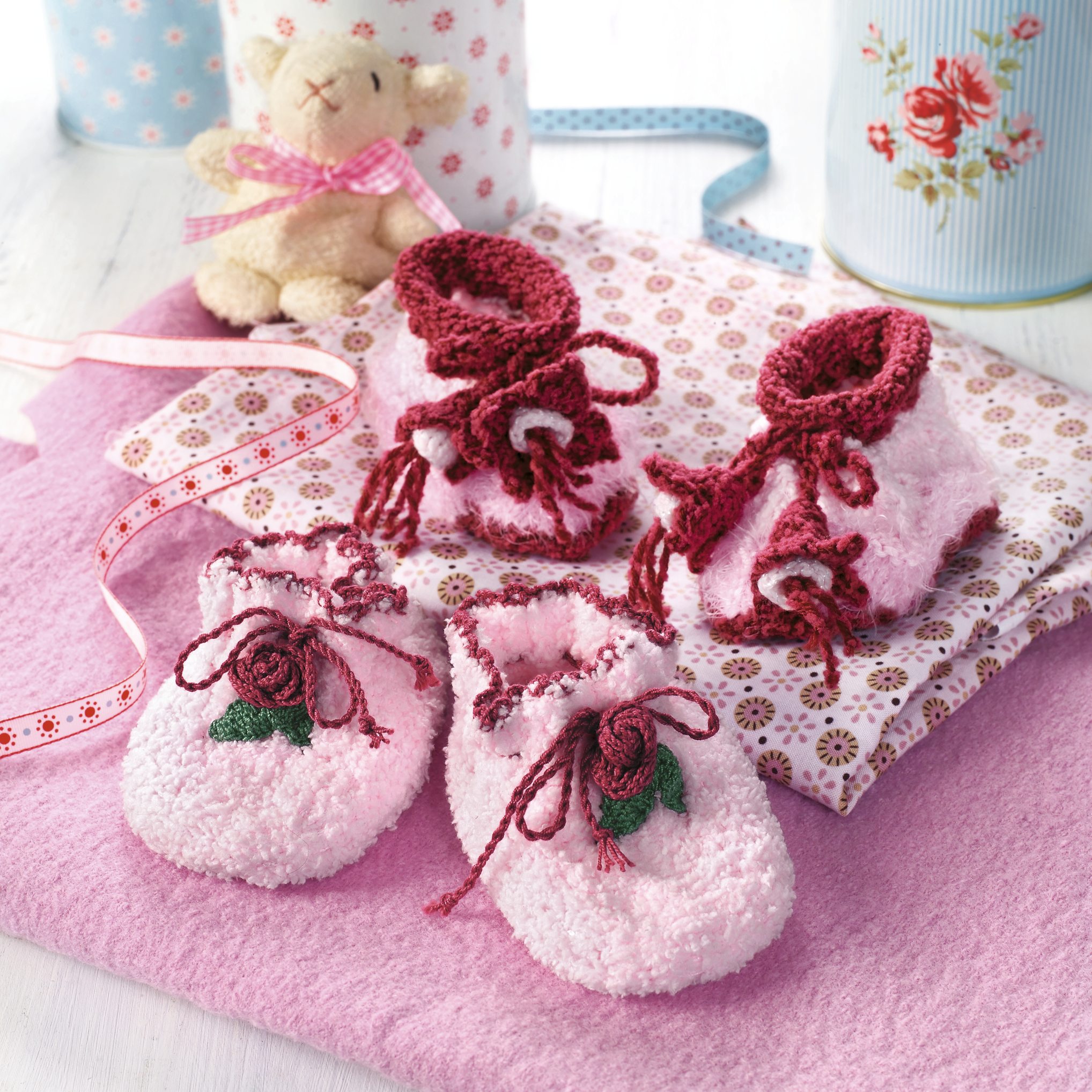 Weiche, rosa Babyschuhe mit handgemachten Blumen, detailverliebt gestrickt, kuschelig und modisch.