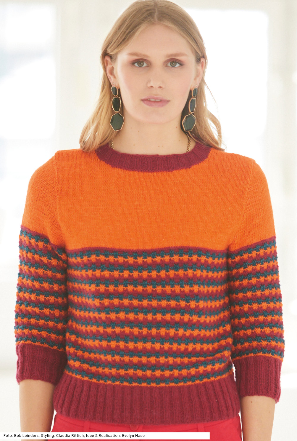 Modellansicht Bild 2: Pulli mit Hebemaschenmuster in Weinrot, Orange und Petrol