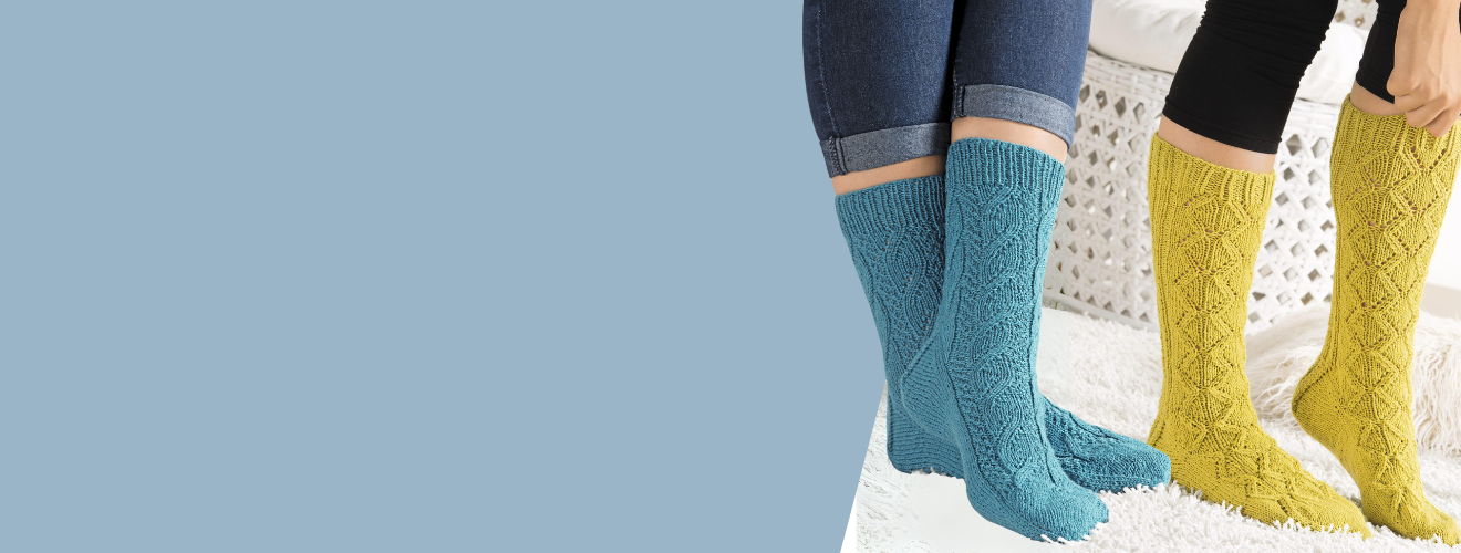Handgestrickte Socken in Blau und Gelb mit Zopfmuster. Bequem, stilvoll, DIY.