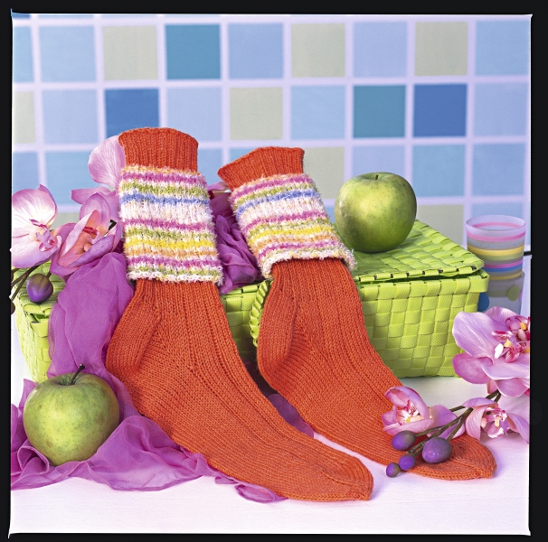 Handgestrickte, orange Socken mit pastellfarbenen Ringelmuster. Modisch und individuell.