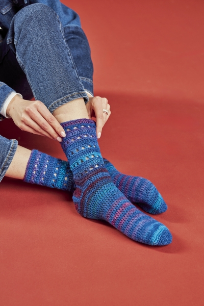 Handgemachte Socken in Blau- und Lilatönen, bunt gemustert und modisch, aus grobem Strick.