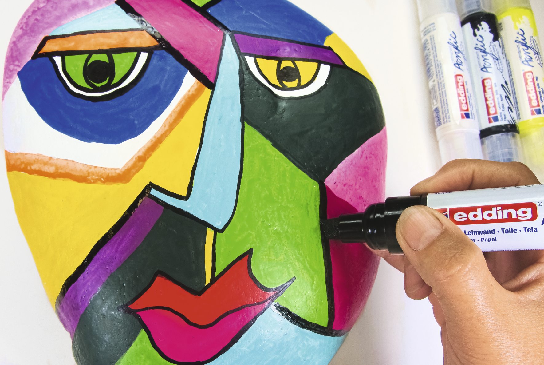Bunte, handgemachte Maske im Picasso-Stil. Lebendige Farben, markante Linien. Modische DIY-Kunst.