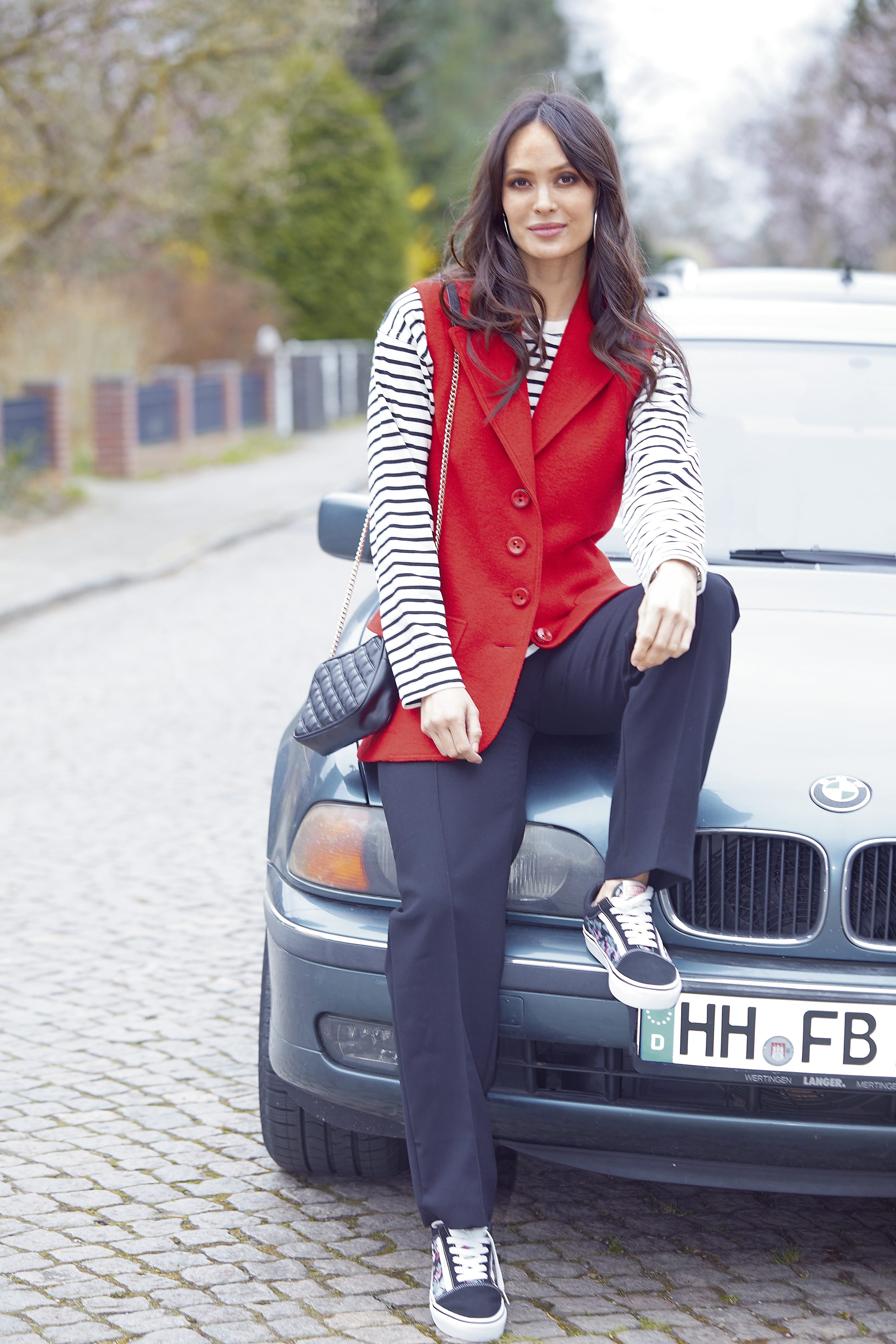 Rot-graue Weste, schwarz-weiße Streifen, lässig, modern, modisch, quer gestreift, weite Hose, Sneaker.