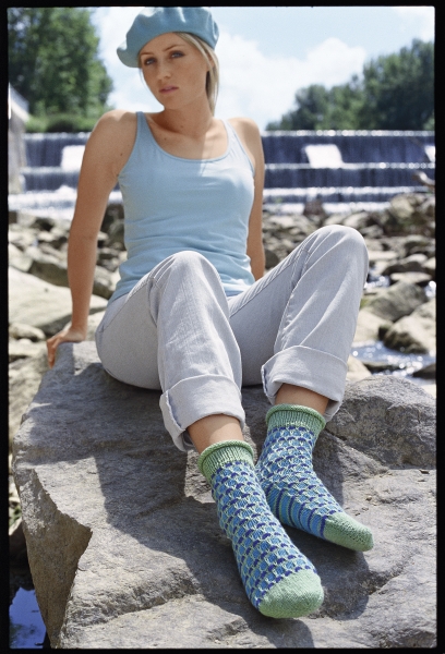 Modisch, selbstgemachte Stricksocken in Blau und Grün, mit geometrischem Muster. Lässiger, heller Sommerlook.