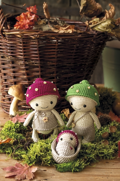 Handgemachte Pilzfiguren, bunte Mützen in Rot und Grün, DIY-Stil, niedliche Details.