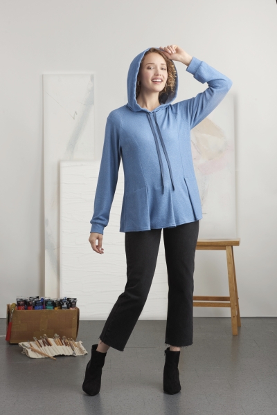 Blauer Hoodie, fließender Schnitt, modisch kombiniert mit schwarzen, knöchellangen Hosen. Stilvoll elegant.