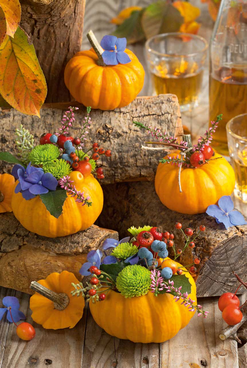 Leuchtende Kürbisse mit Blumenarrangements, färbenfroh, DIY-Deko, herbstlich, handgemacht, stilvoll.