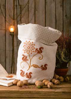 Handgemachter Beutel mit floralen Stickereien, warmen Erdtönen und gepunktetem Innenfutter. Elegantes DIY-Design.
