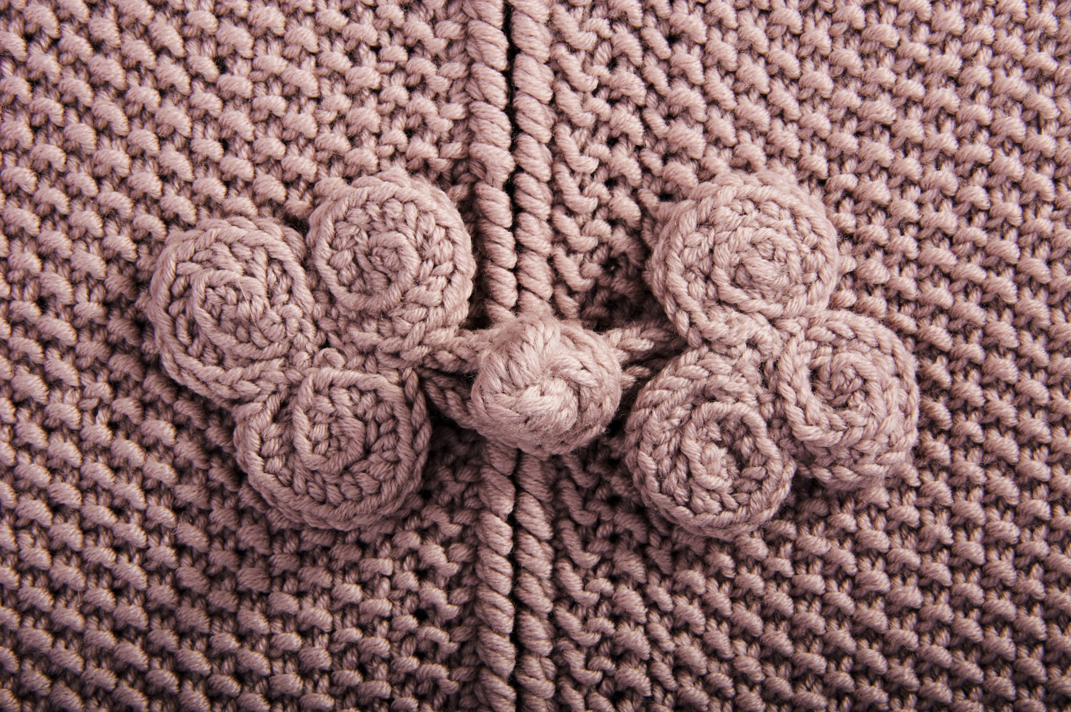 Rosa, selbstgemachter Strick mit Blumendetails, DIY, strukturierte Oberfläche, handgefertigt, kreativ, modisch.