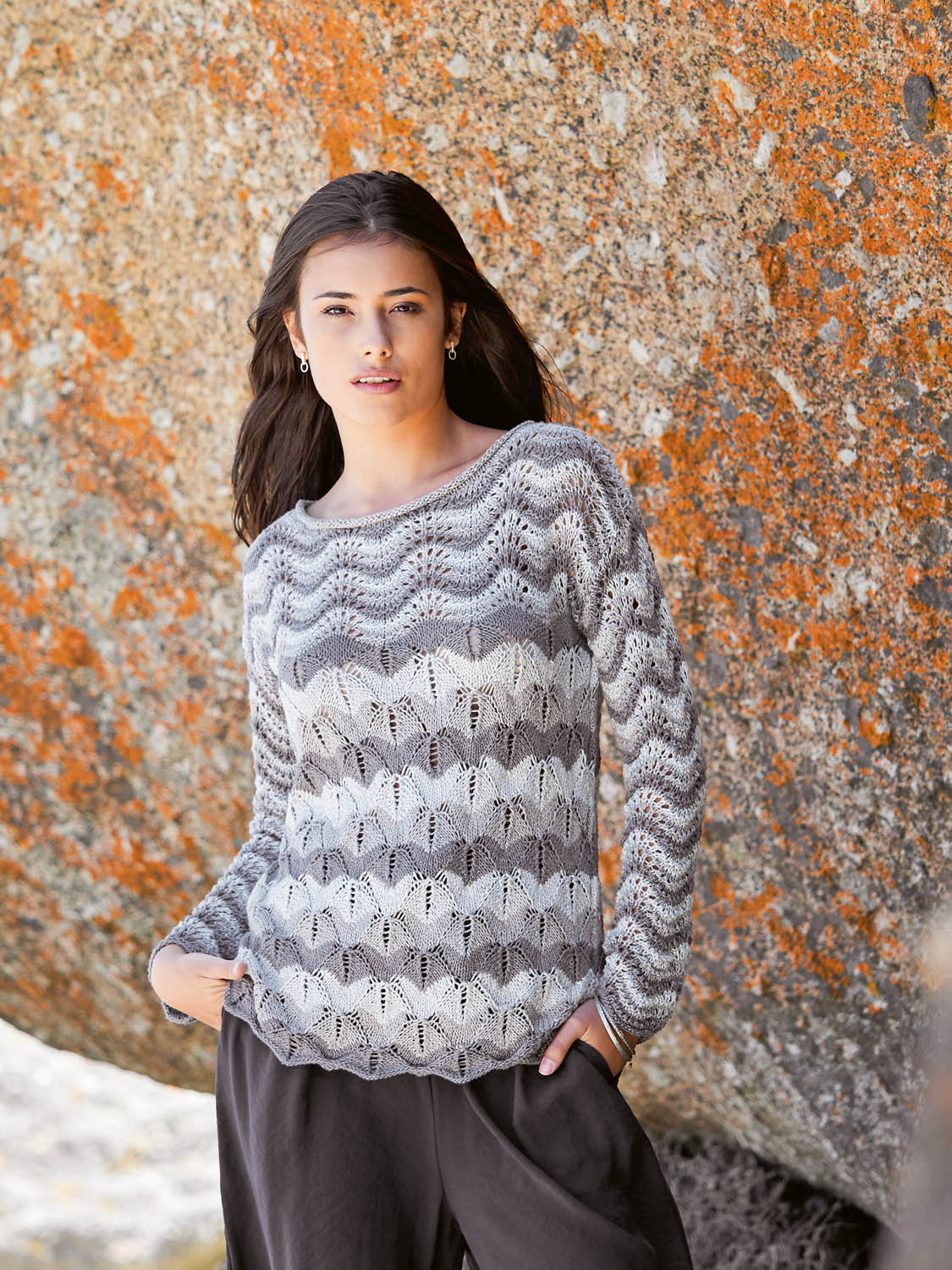 Grauer Strickpullover mit Wellenmuster, luftig, handgemacht und stilvoll, ideal für modische Outfits.