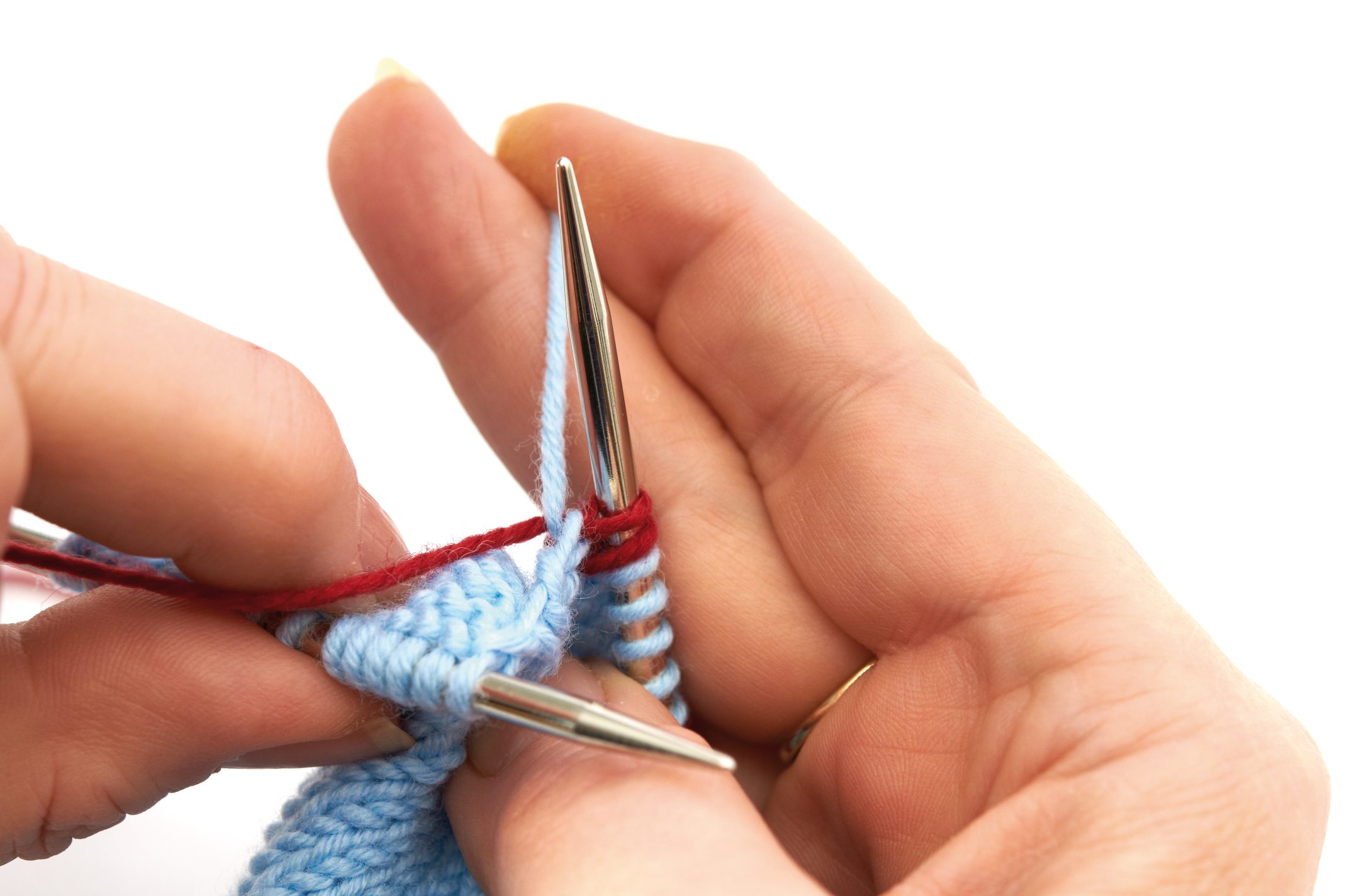 Blaues Strickmuster mit roten Akzenten, handgemachte DIY-Technik, geschickte Nadelarbeit.
