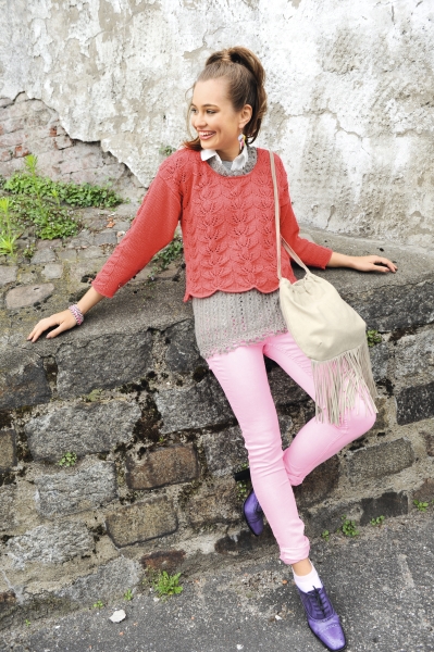 Roter Strickpullover über grauem Shirt, kombiniert mit rosa Hose. DIY-Tasche mit Fransen, modische Farbtöne.