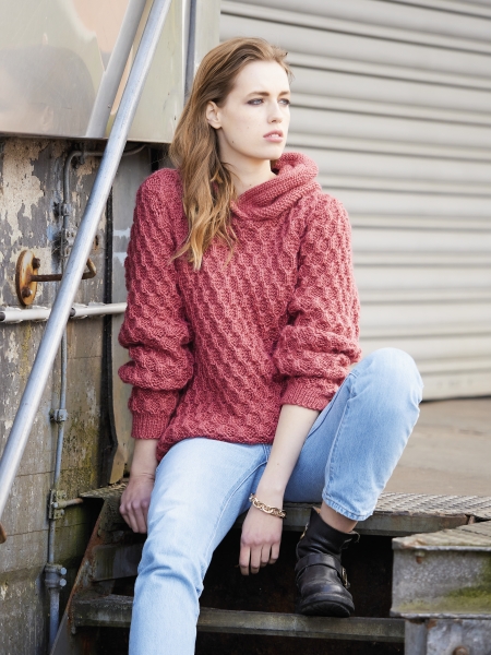 Roter Strickpullover mit Zopfmuster, lockerer Schnitt. Kombiniert mit hellen Jeans, schwarze Stiefel. Modisch, handgemacht.