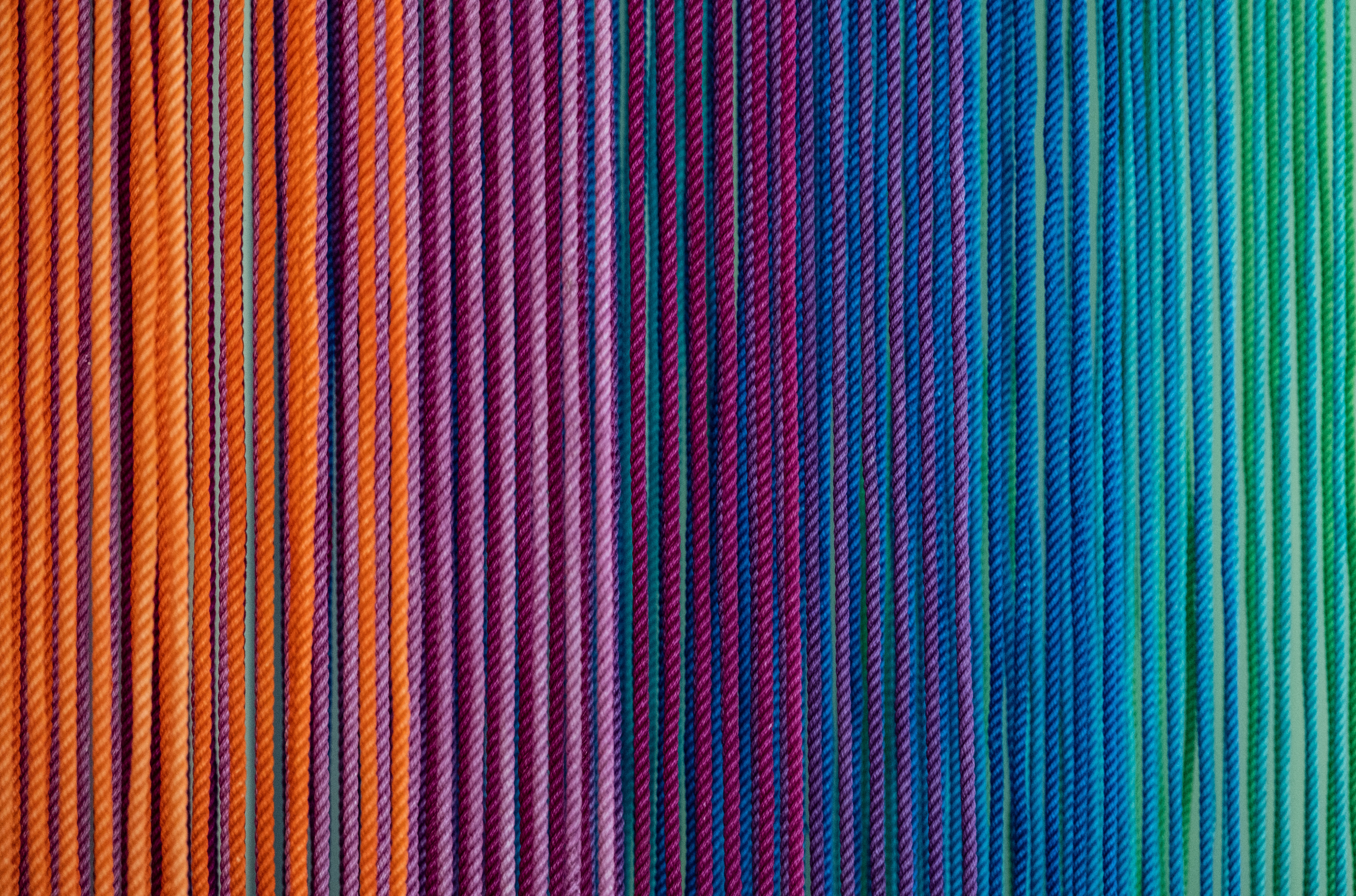 Farbenfrohe FĂ€den in Regenbogenfarben; ideal fĂŒr modische DIY-Handarbeit.