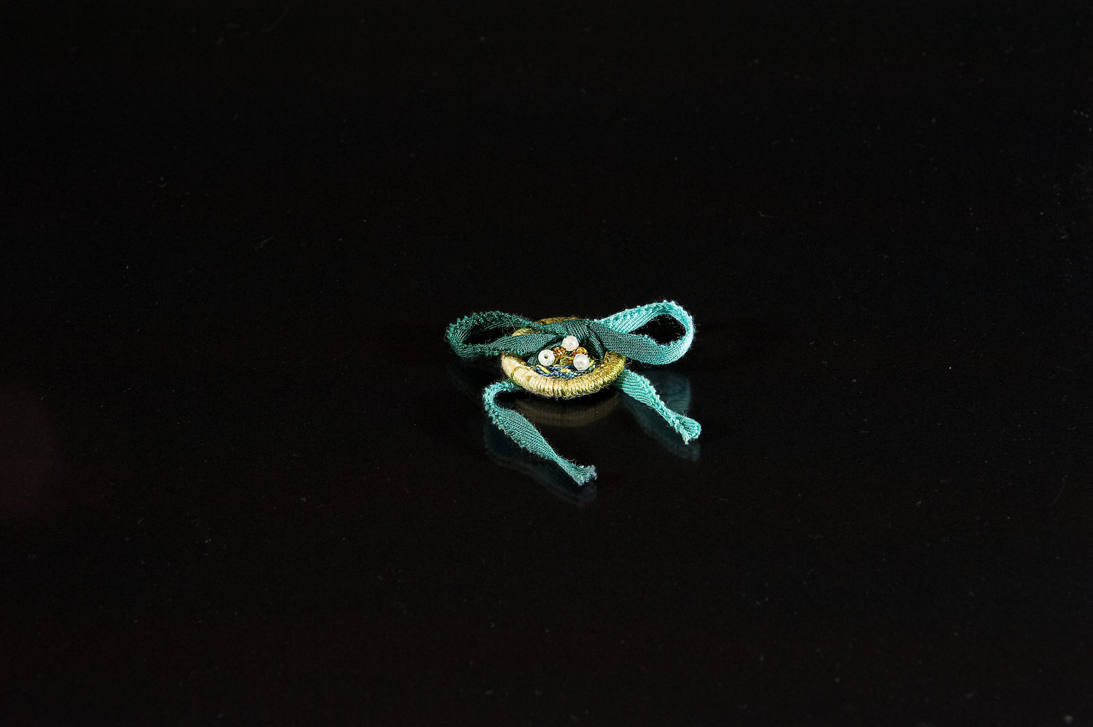 Kleines, türkises DIY-Accessoire mit feinen Perlen. Handarbeit, modisch, einzigartiges Muster.