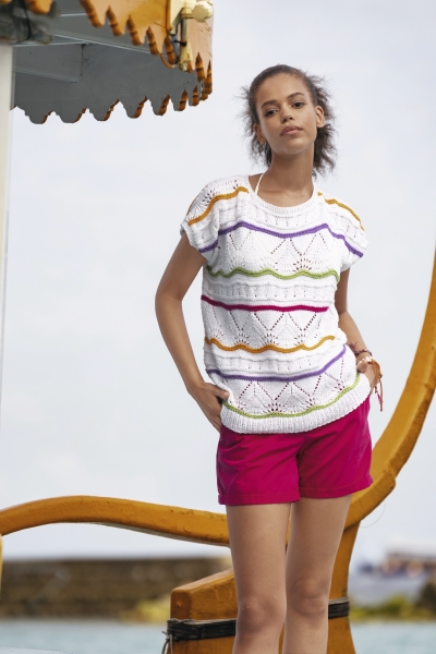Bunt gestreifter, handgemachter Pullover mit Lochmuster; kombiniert mit stilvollen, pinken Shorts.