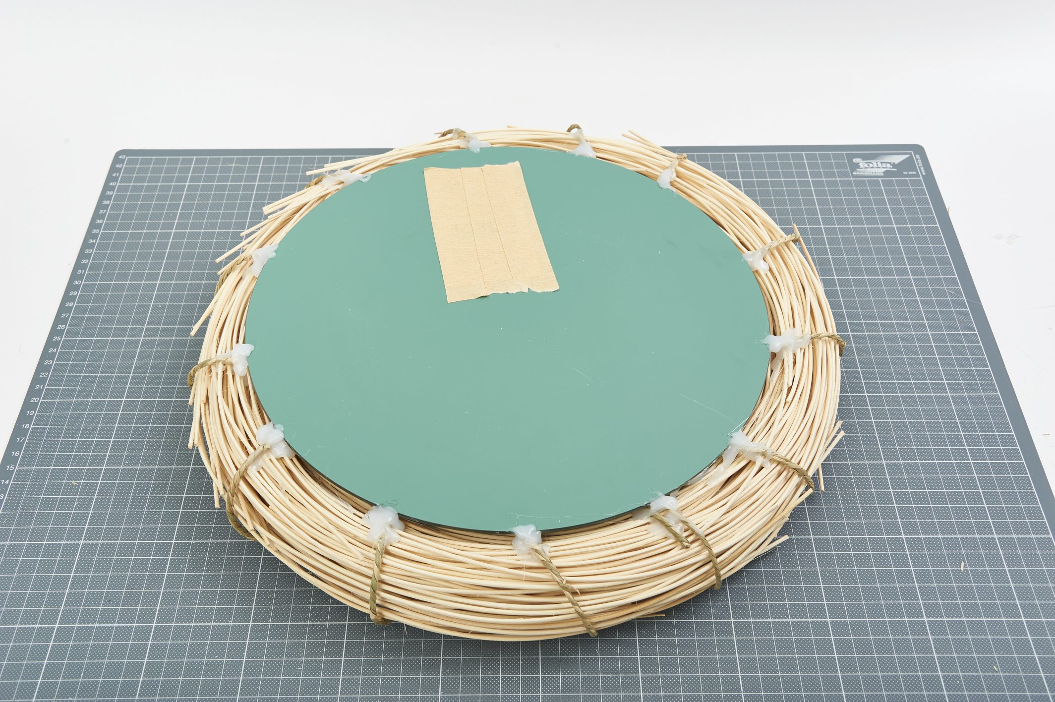 DIY Kranz mit natürlichem Bast. Grüner Einsatz als Akzent. Handarbeit mit kreativer Note.