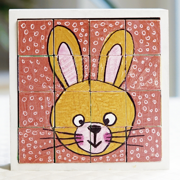 Handgemachtes Puzzle mit buntem Hasenmotiv. Kreativ, verspielt, quadratische Muster, lebendige Farben.
