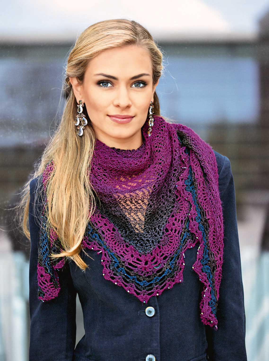 Violetter, gehäkelter Schal mit Spitzenmuster, handgemacht, modisch auf tiefblauem Blazer drapiert.