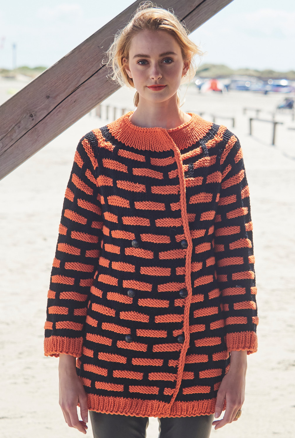 Lange Jacke und Clutch im Hebemaschenmuster in Orange und Schwarz