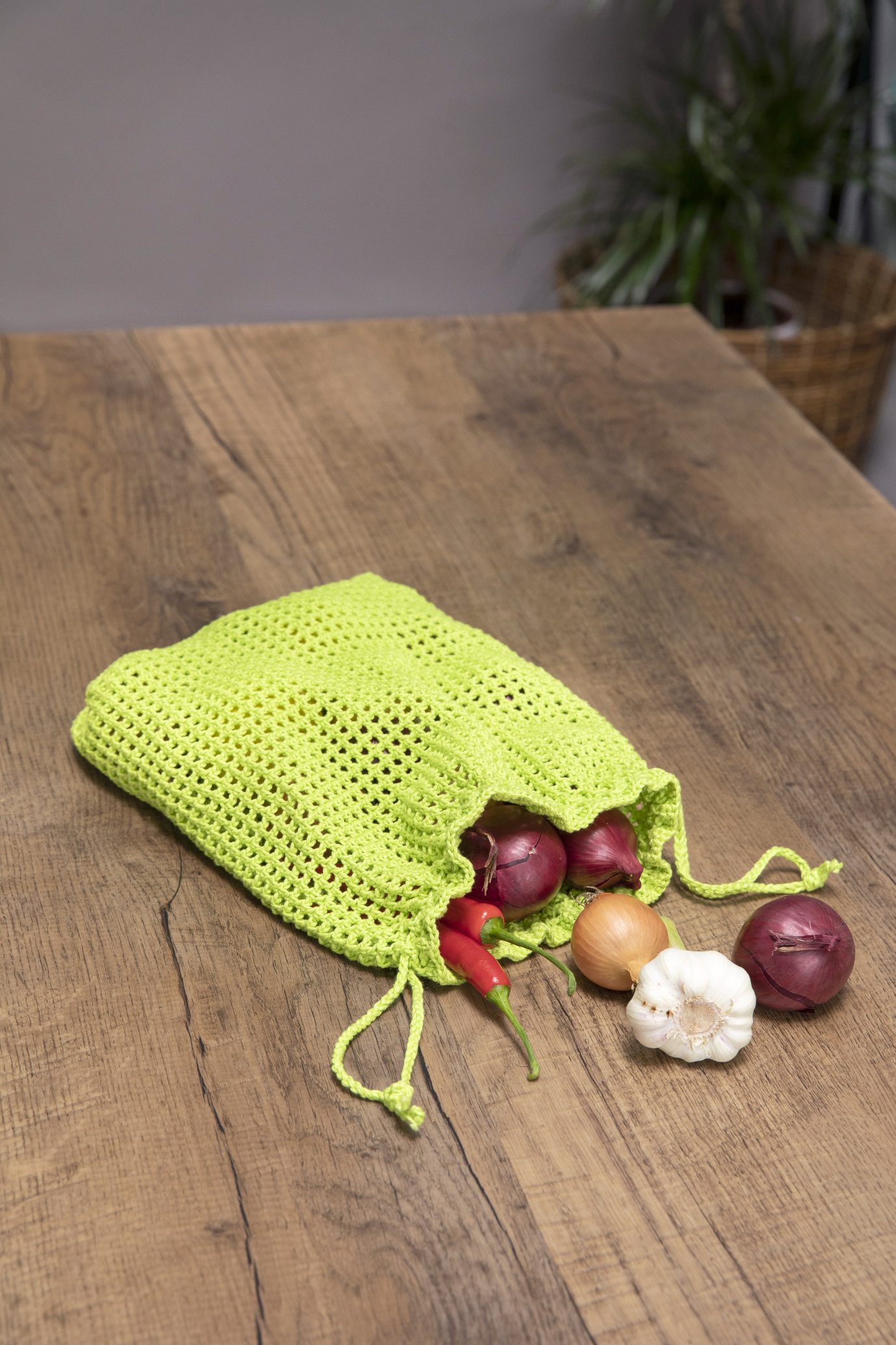 Leuchtend grüner, gehäkelter Beutel; feines Muster, ideal für Obst oder Gemüse. DIY, modisch, nachhaltig.